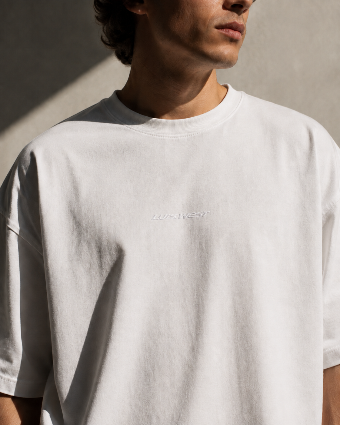 OCEAN SUNRISE T-SHIRT by Luis West, front: the LUIS WEST wordmark embroidered white on white