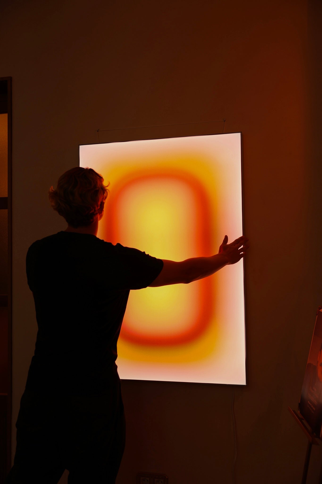 Luis West with the MALIBU SUNRISE lightbox, canvas lit from within in a brushed aluminium frame