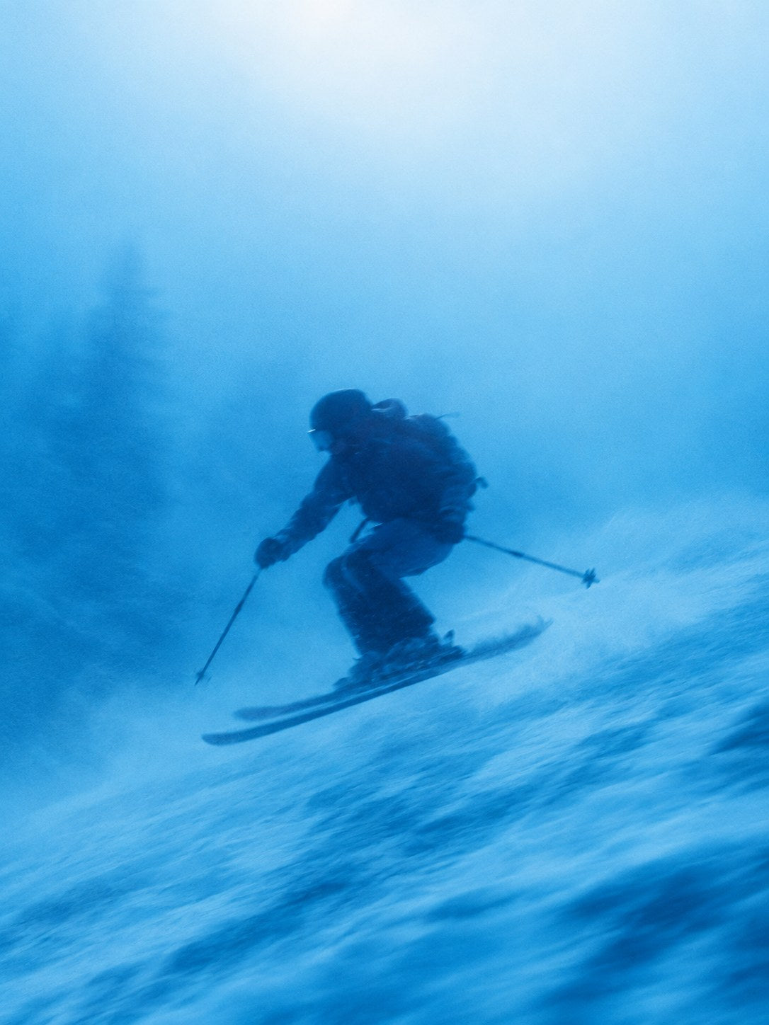 Skier carving through blue powder