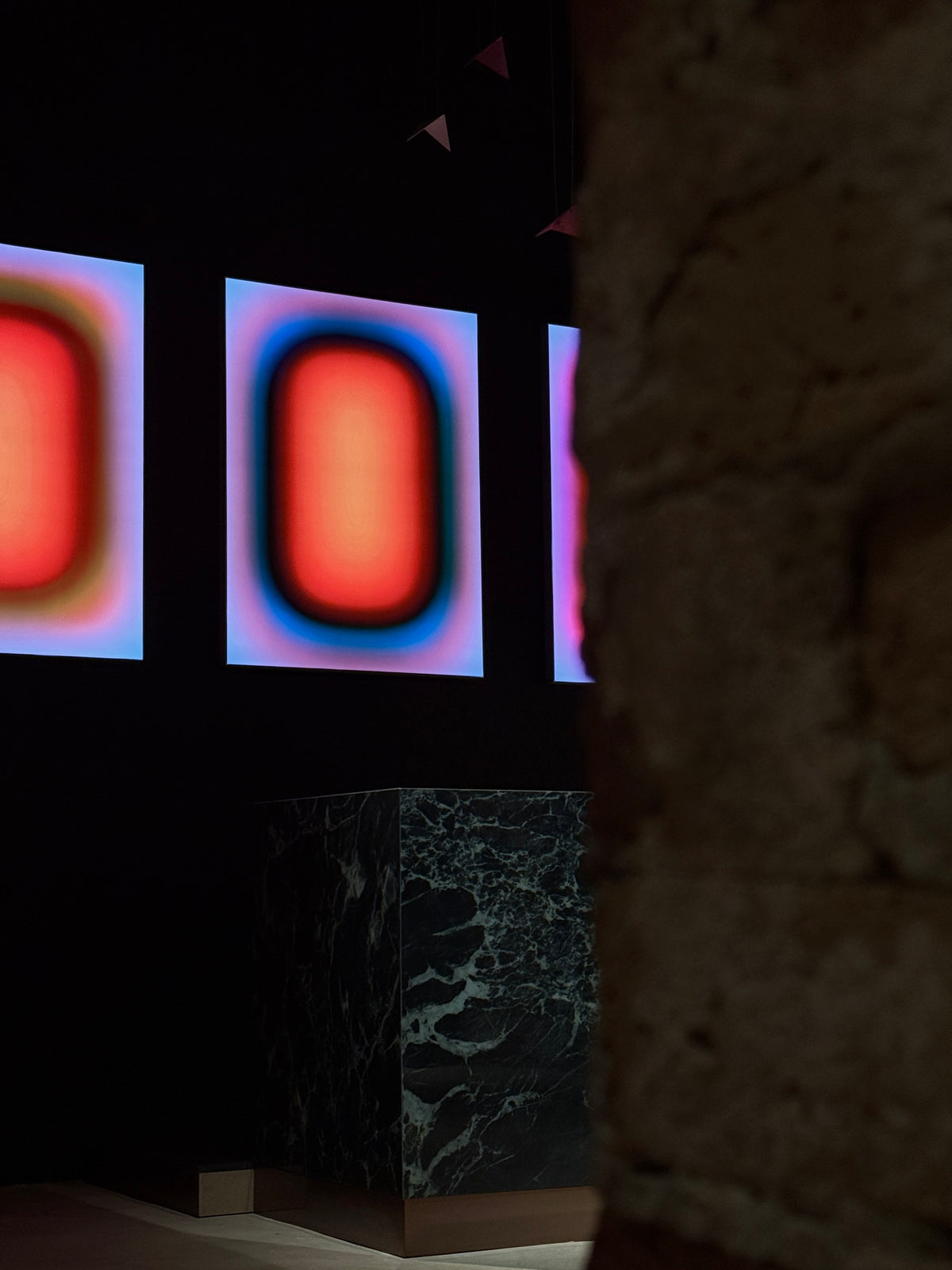 Three Luis West lightboxes installed at John Reed Bötzow in Berlin, glowing against a dark wall
