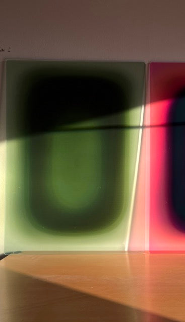 SPRUCE GREEN PILL by Luis West leaning against the wall in sunlight, next to a pink pill artwork
